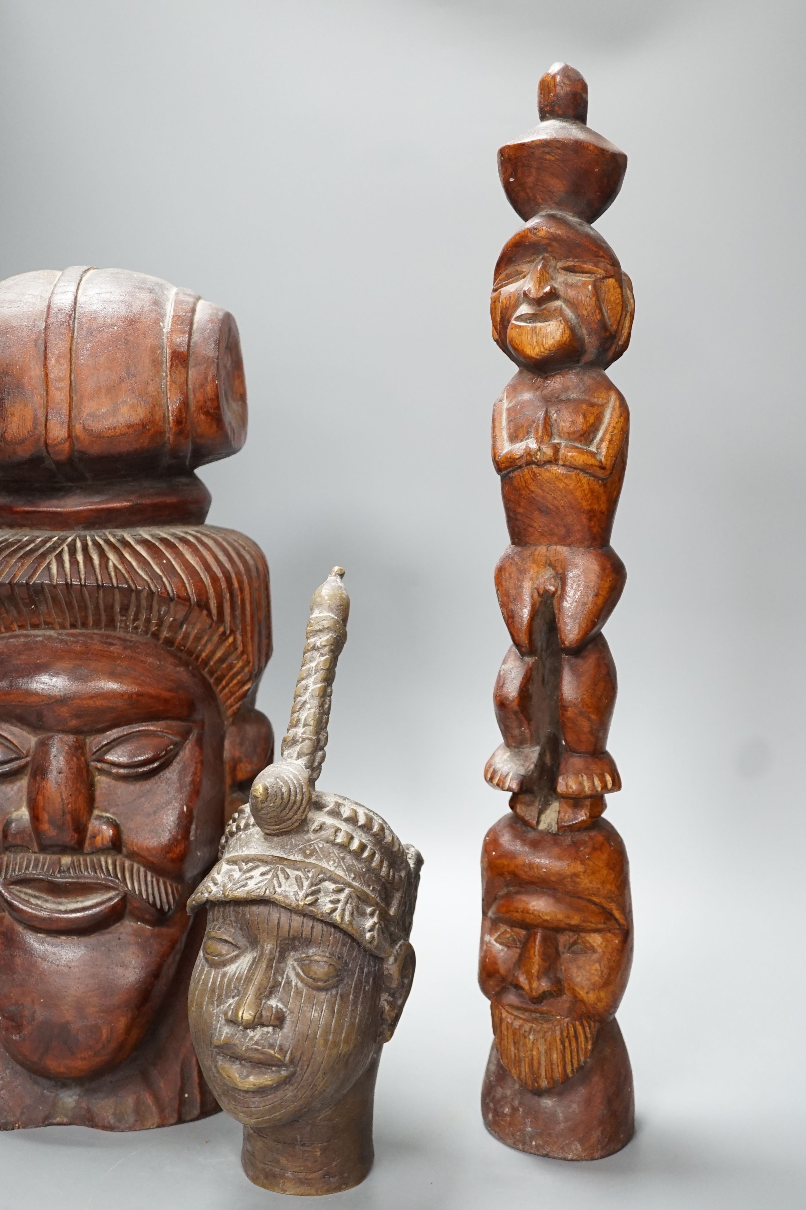 A metal Benin style bust, a carved tribal bust and another